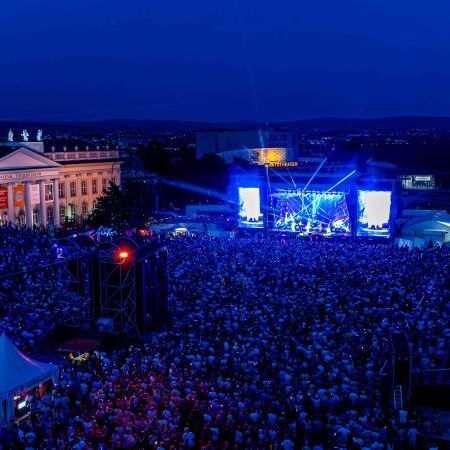 Tausende Besucher erleben ein Open-Air-Konzert beim StadtSommer Kassel. Mobile Tribünen von Bender Tribünen bieten beste Sicht auf die Bühne am Friedrichsplatz.